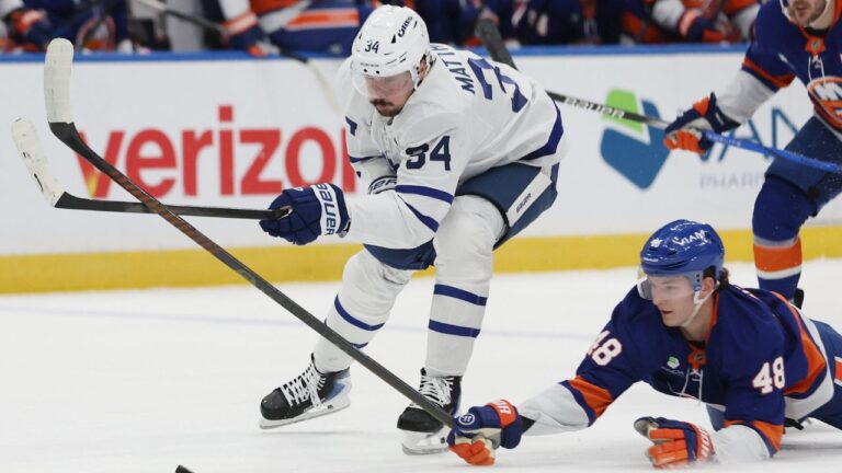 New York Islanders' Matthew Schaefer (48) reaches for the puck against Toronto Maple Leafs centre Auston Matthews, left, during the first period of an NHL hockey game, Saturday, Jan. 3, 2026, in Elmont, N.Y. (Heather Khalifa/AP)