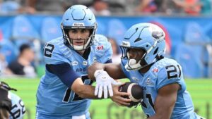 Toronto Argos quarterback Chad Kelly (12) hands off to running back Isaiah Smith (21) during first half CFL football action against the Ottawa Redblacks, (Jon Blacker/THE CANADIAN PRESS)
