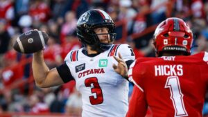 Ottawa Redblacks quarterback McLeod Bethel-Thompson, left, throws the football as Calgary Stampeders' Clarence Hicks looks on during second half CFL football action in Calgary, Saturday, Sept. 19, 2026. (Jeff McIntosh/THE CANADIAN PRESS)