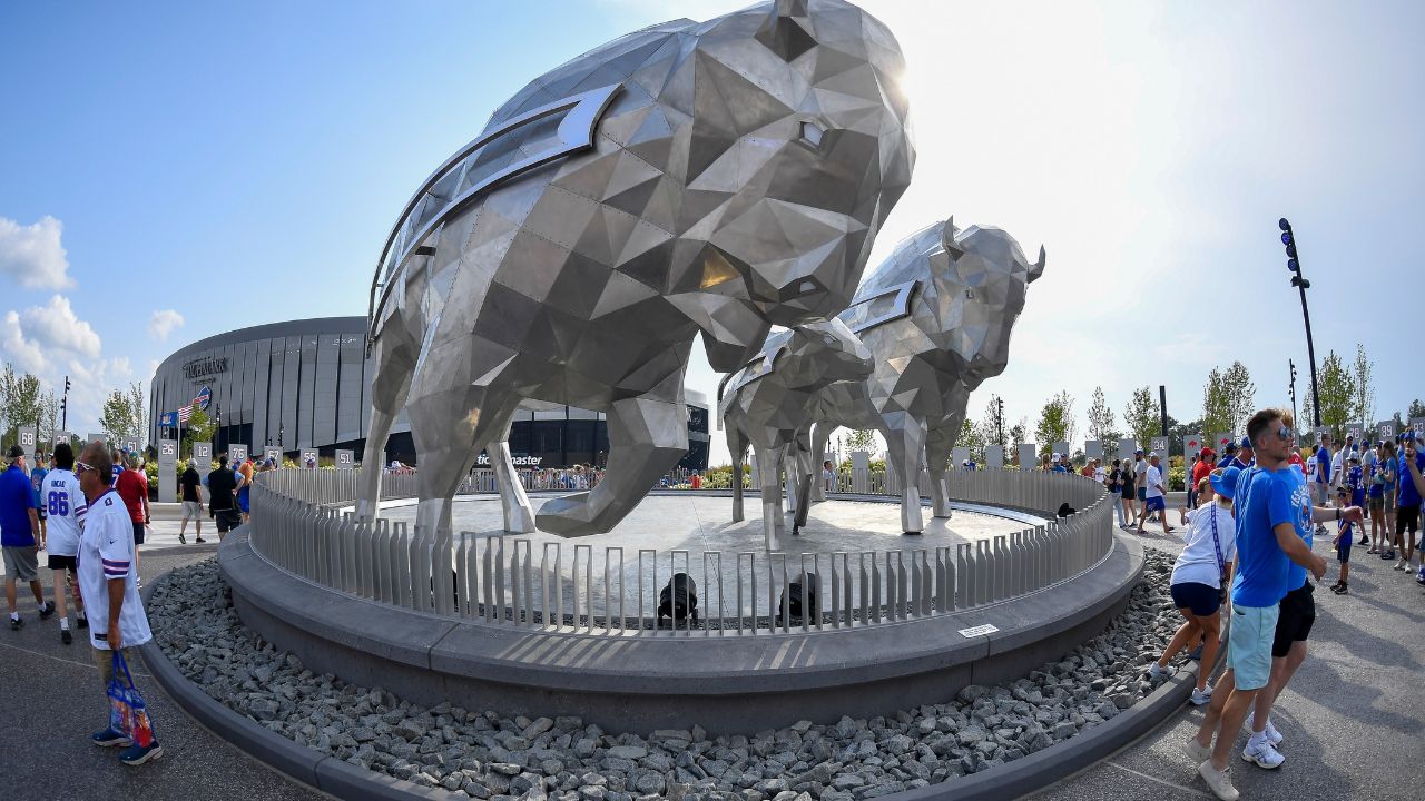 Buffalo Bills fans pose in front of bison sculptures outside Highmark Stadium before practice at the team's NFL football training camp Saturday, Aug. 8, 2026, in Orchard Park, N.Y. (Adrian Kraus/AP Photo)