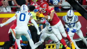 Kansas City Chiefs tight end Travis Kelce (87) scores past Indianapolis Colts safety Cam Bynum (0) and cornerback Justin Walley (27) during the first half of an NFL football game Sunday, Sept. 20, 2026, in Kansas City, Mo. (Charlie Riedel/AP)