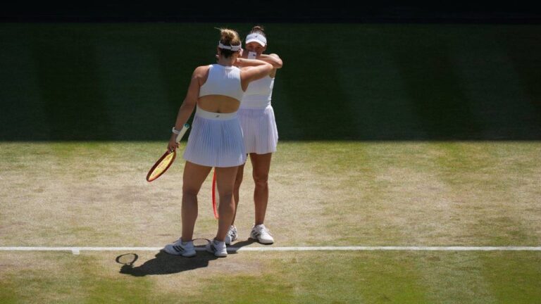 Luisa Stefani of Brazil and Gabriela Dabrowski of Canada, back to the camera, speak between points against Guo Hanyu of China and Kristina Mladenovic of France in the women's doubles final at Wimbledon Tennis Championships in London, Sunday, July 12, 2026. (Kirsty Wigglesworth/AP)