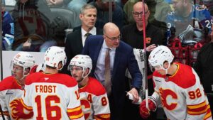 Calgary Flames head coach Ryan Huska confers with right wing Matvei Gridin (92) in the first period of an NHL hockey game. (David Zalubowski/AP)