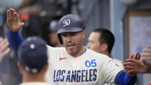 Los Angeles Dodgers' Freddie Freeman is congratulated by teammates in the dugout after scoring on a single by Teoscar Hernandez during the first inning of a baseball game against the Washington Nationals, Saturday, Sept. 5, 2026, in Los Angeles. (Mark J. Terrill/AP)