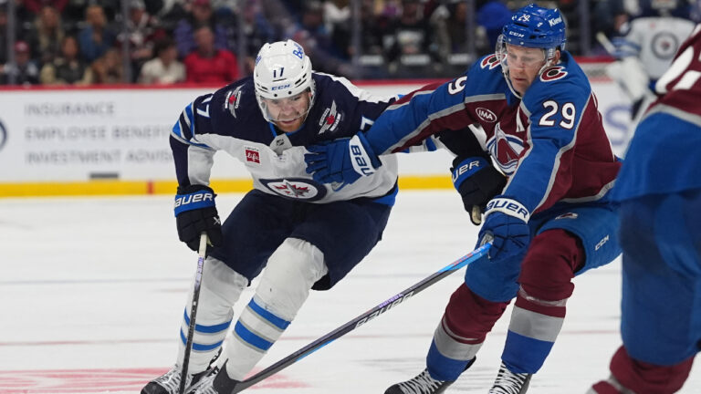 Winnipeg Jets centre Adam Lowry, left, pursues the puck with Colorado Avalanche center Nathan MacKinnon in the second period of a preseason NHL hockey game Friday, Sept. 25, 2026, in Denver. (David Zalubowski/AP)