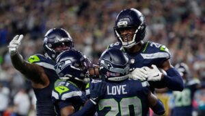 Seattle Seahawks cornerback Josh Jobe, top right, celebrates after intercepting a pass in the end zoe with teammates including safety Julian Love, bottom right, during the second half of an NFL football game against the New England Patriots, Wednesday, Sept. 9, 2026, in Seattle. (Stephen Brashear/AP Photo)