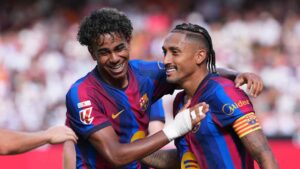 Barcelona's Raphinha, right, celebrates with teammate Lamine Yamal after scoring his side's third goal during the Spanish La Liga soccer match between Valencia and Barcelona. (Alberto Saiz/AP)