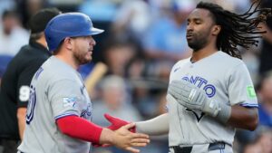 Toronto Blue Jays' Alejandro Kirk, left, and Charles McAdoo celebrate after they scored on a two-run double by Ernie Clement during the first inning of a baseball game against the Kansas City Royals, Friday, Sept. 4, 2026, in Kansas City, Mo. (Charlie Riedel/AP Photo)