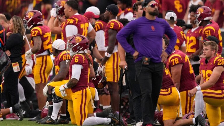 Members of Southern California take a knee while Oregon quarterback Dante Moore is attended to following a hard tackle by linebacker Desman Stephens II during the first half of an NCAA college football game, Saturday, Sept. 26, 2026, in Los Angeles. (AP/Mark J. Terrill)