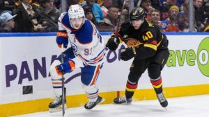Edmonton Oilers' Ryan Nugent-Hopkins (93) skates with the puck in front of Vancouver Canucks' Elias Pettersson (40) during the second period of an NHL hockey game in Vancouver, on Saturday, January 17, 2026. (Darryl Dyck/CP)
