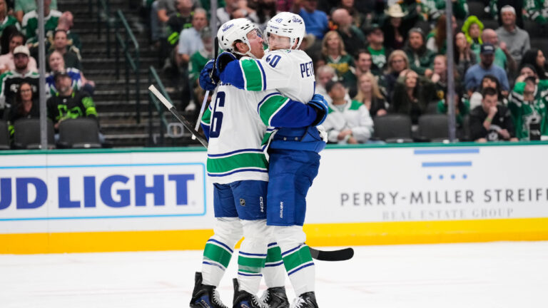 Vancouver Canucks' Brock Boeser, left, and Elias Pettersson, right, celebrate Boeser's goal in the second period of an NHL hockey game against the Dallas Stars Thursday, Oct. 16, 2025, in Dallas. (Tony Gutierrez/AP)