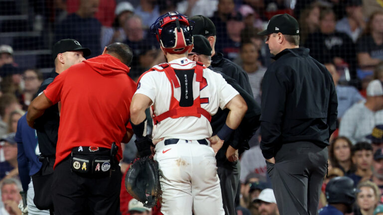 A game delay was called after the home plate umpire, far left, was hit by a pitch during the sixth inning of a baseball game between the Boston Red Sox and Seattle Mariners, Tuesday, Sept. 1, 2026, in Boston. (Mark Stockwell/AP)