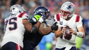 Seattle Seahawks nose tackle Byron Murphy II, centre, pressures New England Patriots quarterback Drake Maye, right, as New England Patriots guard Alijah Vera-Tucker, right, moves in during the second half of an NFL football game, Wednesday, Sept. 9, 2026, in Seattle. (Lindsey Wasson/AP Photo)