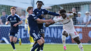 Vancouver Whitecaps' J.C. Ngando (26) and teammate Mihail Gherasimencov (29) collide while vying for the ball against Cavalry FC's Goteh Ntignee (20) during the first half of a Canadian Championship quarterfinal soccer match, in Burnaby, B.C., on Wednesday, July 8, 2026. (Darryl Dyck/CP)