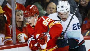 Seattle Kraken's Ryan Winterton, right, checks Calgary Flames' Matvei Gridin during second period NHL hockey action in Calgary on Thursday, Oct. 1, 2026. (Jeff McIntosh/CP)