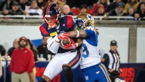 Montreal Alouettes' Tyson Philpot, left, makes the catch as Winnipeg Blue Bombers' Trey Vaval defends during first half CFL football action in Montreal Saturday, Oct. 3, 2026. (Peter McCabe/CP)
