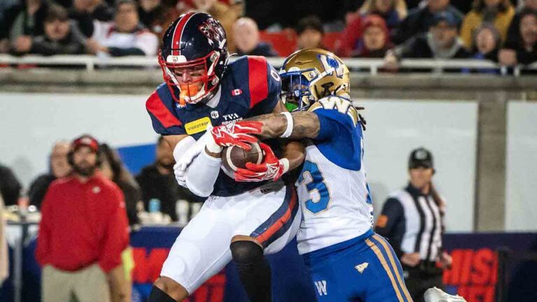 Montreal Alouettes' Tyson Philpot, left, makes the catch as Winnipeg Blue Bombers' Trey Vaval defends during first half CFL football action in Montreal Saturday, Oct. 3, 2026. (Peter McCabe/CP)