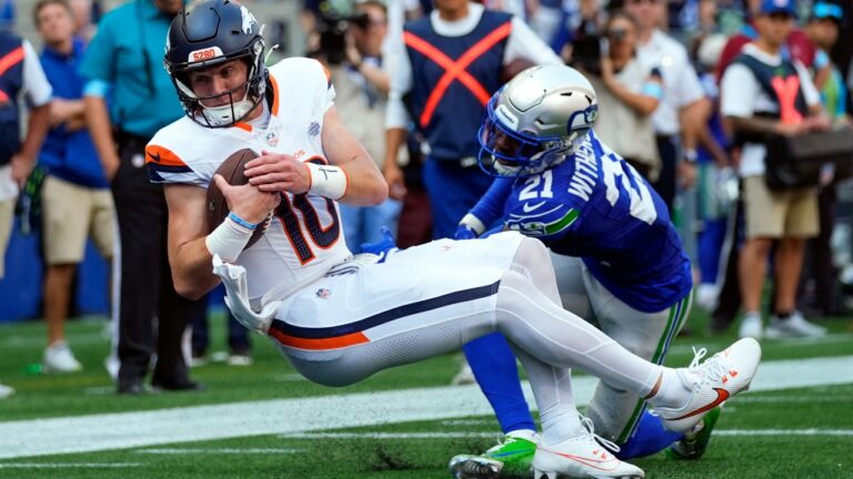 Denver Broncos quarterback Bo Nix scores a touchdown while being tackled by Seattle Seahawks cornerback Devon Witherspoon during an NFL football game, Sunday, Sept. 8, 2024, in Seattle. The Seahawks won 26-20. (Lindsey Wasson/AP)
