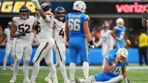 Los Angeles Chargers quarterback Justin Herbert, right, sits on the ground after being sacked and losing the ball on the last play of the game as members of the Denver Broncos celebrate during the second half of an NFL football game, Sunday, Oct. 11, 2026, in Inglewood, Calif. (AP Photo/Gregory Bull)