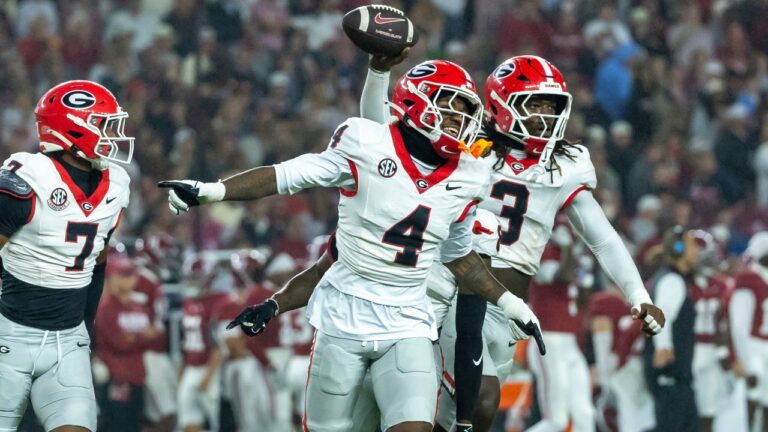 Georgia defensive back KJ Bolden (4) and linebacker Quintavius Johnson (3) celebrate after Johnson's fumble recovery during the first half of an NCAA college football game against Alabama, Saturday, Oct. 10, 2026, in Tuscaloosa, Ala. (Vasha Hunt/AP)