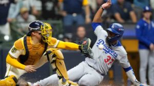 Los Angeles Dodgers' Teoscar Hernández is forced out at home by Milwaukee Brewers catcher William Contreras during the fourth inning in Game 1 of baseball's National League Championship Series, Monday, Oct. 13, 2025, in Milwaukee. (Brynn Anderson/AP)