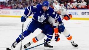 Toronto Maple Leafs' John Tavares (91) battles with New York Islanders' Adam Pelech (3) during second period NHL hockey action in Toronto on Wednesday, Sept. 30, 2026. (Frank Gunn/CP)
