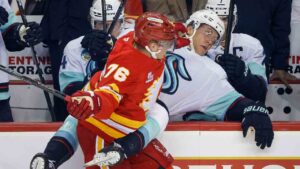 Seattle Kraken's Ryker Evans, right, is checked by Calgary Flames' Martin Pospisil during first period NHL hockey action in Calgary on Thursday, Oct. 1, 2026. (Jeff McIntosh/CP)