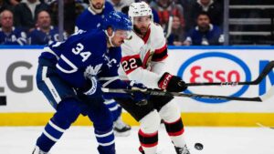 Toronto Maple Leafs' Auston Matthews (34) and Ottawa Senators' Michael Amadio (22) battle for the puck during third period NHL hockey action in Toronto on Saturday, Oct. 3, 2026. (Frank Gunn/CP)