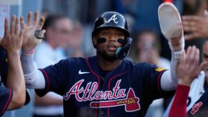 Atlanta Braves' Ronald Acuña Jr. celebrates with teammates after scoring off an RBI single by Mauricio Dubón during the first inning of Game 2 of a National League Division Series baseball game against the Los Angeles Dodgers Sunday, Oct. 4, 2026, in Los Angeles. (Mark J. Terrill/AP)