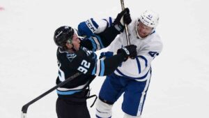 Utah Mammoth centre Logan Cooley (92) and Toronto Maple Leafs defenceman Darren Raddysh (43) get tangled up playing the puck during the first period of an NHL hockey game, Tuesday, Oct. 13, 2026, in Salt Lake City. (Tyler Tate/AP)