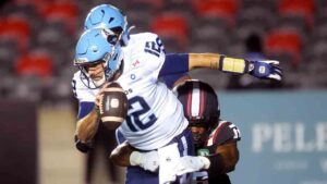 Toronto Argonauts quarterback Chad Kelly (12) is sacked by Ottawa Redblacks linebacker Aaron Casey (36) during first half CFL action in Ottawa, Friday, Oct. 16, 2026. (Adrian Wyld/CP)