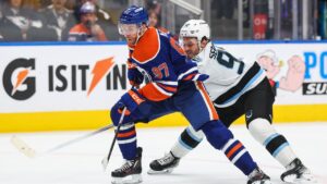 Edmonton Oilers' Connor McDavid (97) protects the puck from Utah Mammoth's Mikhail Sergachev (98) during second period NHL hockey action in Edmonton on Thursday, Oct. 15, 2026. (Codie McLachlan/CP)