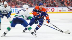 Edmonton Oilers' Connor McDavid (97) skates in against Vancouver Canucks' Tom Willander (5) during second period NHL hockey action in Edmonton on Tuesday, Sept. 29, 2026. (Codie McLachlan/CP)