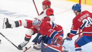 Carolina Hurricanes' Taylor Hall (71) trips over Montreal Canadiens goaltender Jakub Dobes (75) as Canadiens' Juraj Slafkovsky (20) defends during first period NHL hockey action in Montreal on Tuesday, Oct. 6, 2026. (Christinne Muschi/CP)