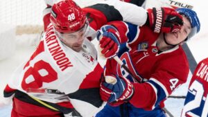 Montreal Canadiens' Lane Hutson (right) and Carolina Hurricanes' Jordan Martinook battle in front of the net during first period NHL hockey action in Montreal on Tuesday, Oct. 6, 2026. (Christinne Muschi/CP)