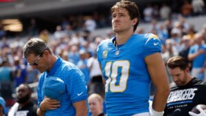 Los Angeles Chargers head coach Jim Harbaugh, left, and quarterback Justin Herbert (10) stand during the national anthem before an NFL football game against the Arizona Cardinals, Sunday, Sept. 13, 2026, in Inglewood, Calif. (AP Photo/Caroline Brehman)