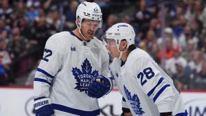 Toronto Maple Leafs defensemen Jake McCabe (22) and Troy Stecher (28) confer in the third period of an NHL hockey game Saturday, Oct. 10, 2026, in Denver. (AP Photo/David Zalubowski)