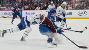 Colorado Avalanche centre Nathan MacKinnon, front right, drives past Toronto Maple Leafs defensemen Morgan Rielly, front left, and Chris Tanev in the first period of an NHL hockey game Saturday, Oct. 10, 2026, in Denver. (AP Photo/David Zalubowski)