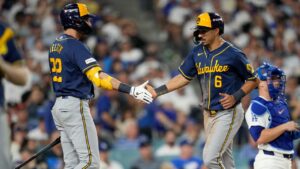 Milwaukee Brewers third baseman David Hamilton (6) greets Milwaukee Brewers designated hitter Christian Yelich (22) after scoring on a base loaded walk by Jake Bauers during the fifth inning of Game 4 of baseball's National League Championship Series between the Milwaukee Brewers and the Los Angeles Dodgers, Thursday, Oct. 15, 2026, in Los Angeles. (Ashley Landis/AP)
