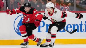 New Jersey Devils' Luke Hughes, left, and Ottawa Senators' Ridly Greig compete during the first period of an NHL hockey game in Newark, N.J., Monday, Oct. 12, 2026. (Seth Wenig/AP)