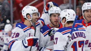 New York Rangers defenseman Sean Durzi, center, celebrates with right wing Oliver Bjorkstrand (28) and right wing Eeli Tolvanen (17) after scoring against the Detroit Red Wings during the first period of an NHL hockey game Friday, Oct. 2, 2026, in Detroit. (Duane Burleson/AP)
