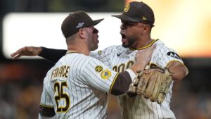 San Diego Padres' Xander Bogaerts, right, and Ty France (25) celebrate a victory over the Milwaukee Brewers in Game 3 of baseball's National League Division Series Tuesday, Oct. 6, 2026, in San Diego. (AP Photo/Gregory Bull)