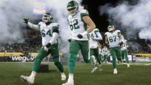Saskatchewan Roughriders' Trevon Tate (64) and teammate Payton Collins (62) lead teammates as they run onto the field prior to first half CFL football action against the Montreal Alouettes at the 112th Grey Cup, in Winnipeg on Sunday, Nov. 16, 2025. (John Woods/CP)