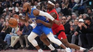 Orlando Magic's Jevon Carter (left) battles for the ball against Toronto Raptors' Ja'kobe Walter (14) during first half NBA basketball action in Toronto on Wednesday, Oct. 28, 2026. (Nathan Denette/CP)