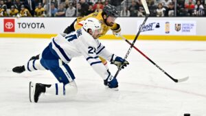 Toronto Maple Leafs Brandon Duhaime, front, and Vegas Golden Knights Rasmus Andersson (4) battle for the puck during the first period of an NHL hockey game Thursday, Oct. 8, 2026, in Las Vegas. (David Becker/AP)