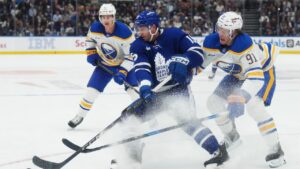 Toronto Maple Leafs' Colton Sissons (15) protects the puck from Buffalo Sabres' Josh Doan (91) during second period NHL hockey action in Toronto on Thursday, Oct. 15, 2026. (Nathan Denette/CP)