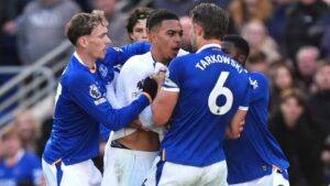 Tempers fray between Chelsea's Morgan Rogers, centre, and Everton's James Tarkowski, resulting in yellow cards to both players, during the English Premier League soccer match between Everton and Chelsea in Liverpool, England, Saturday, Oct. 17, 2026. (Mike Egerton/AP)