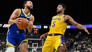 Golden State Warriors guard Stephen Curry (30) handles the ball against Los Angeles Lakers guard Quentin Grimes (5) during the second half of a preseason NBA basketball game Tuesday, Oct. 13, 2026, in Las Vegas. (David Becker/AP)
