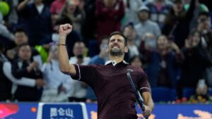 Novak Djokovic, of Serbia reacts after defeating Bu Yunchaokete, of China in a men's singles second round match during the China Open tennis tournament held in Beijing, Friday, Oct. 2, 2026. (AP Photo/Ng Han Guan)