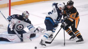 Pittsburgh Penguins' Sidney Crosby (87) can't get off a shot in front of Winnipeg Jets goaltender Clay Stevenson (33) with Dylan DeMelo (2) defending during the first period of an NHL hockey game in Pittsburgh, Monday, Oct. 5, 2026. (AP Photo/Gene J. Puskar)